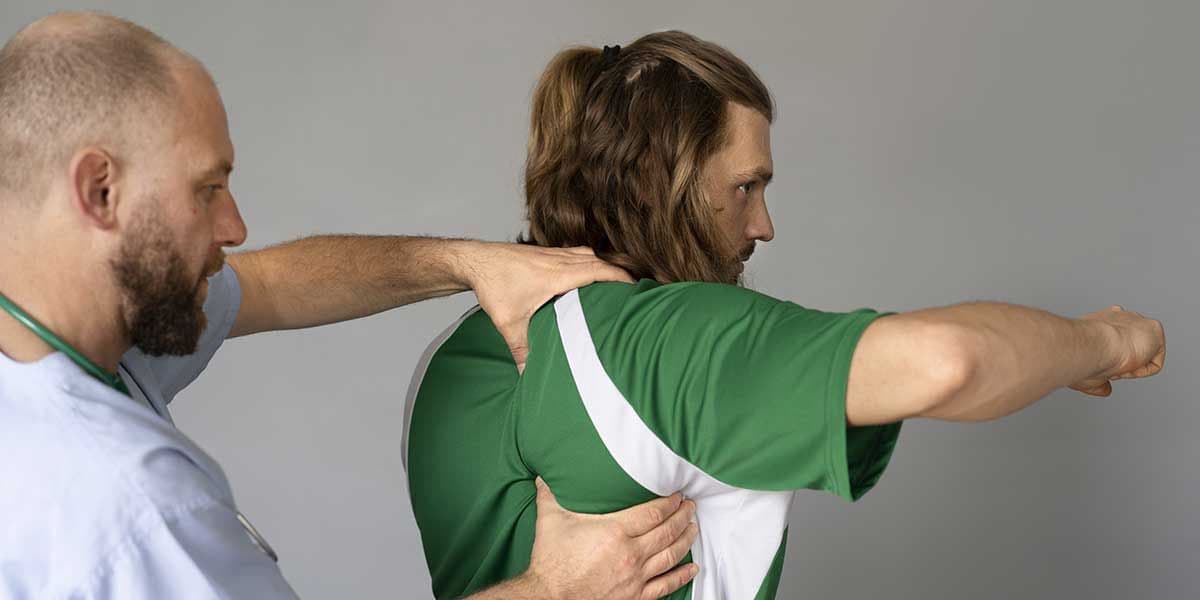 A practitioner examines a patient's upper back and shoulder muscles to evaluate and treat painful muscle knots.